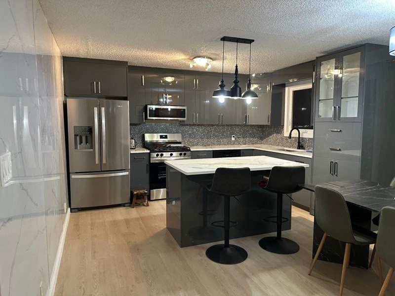 Dark gloss kitchen with marble feature wall by Monarch Cabinets